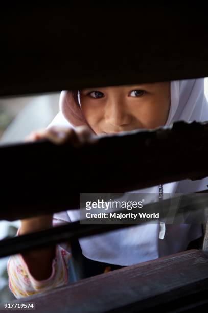 Children look through a slit in the classroom window at Madrasa Aziza Al-Islamia in Barangay Polonuling in Tupi municipality in the province of South...