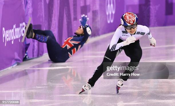 Minjeong Choi of Korea races past as Elise Christie of Great Britain crashes during the Ladies' 500m Short Track Speed Skating final on day four of...