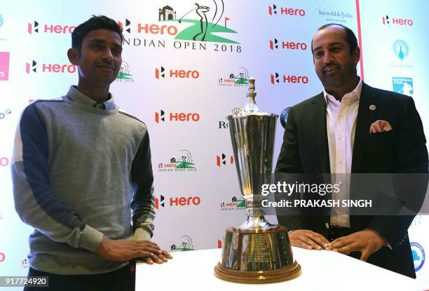 Indian golfers Rashid Khan and Shiv Kapur pose with the Hero Indian Open trophy during a press conference for "India Open 2018" golf tournament in...