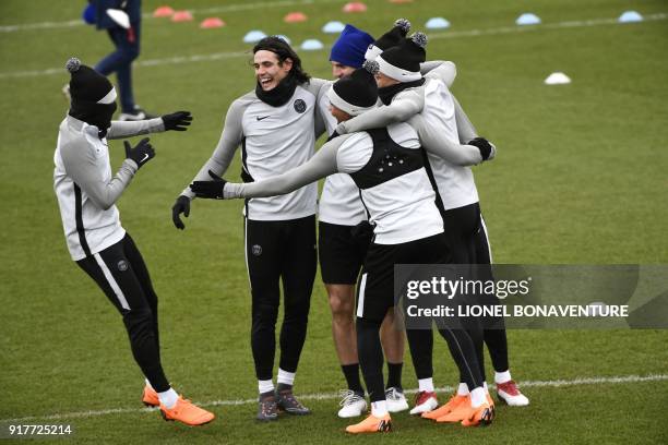 Paris Saint-Germain's Brazilian forward Neymar Jr, Paris Saint-Germain's Uruguayan forward Edinson Cavani and their teammates joke during a training...