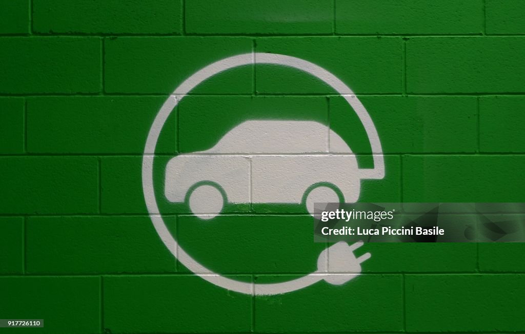 Elektro-Fahrzeug parken nur anmelden, grünen Ziegel Wand Hintergrund.