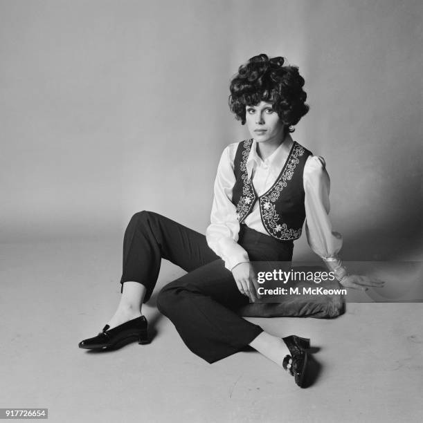 British actress and fashion model Joanna Lumley wearing black crepe two piece embroidered in silver bolero and trousers, white satin deep cuffed...