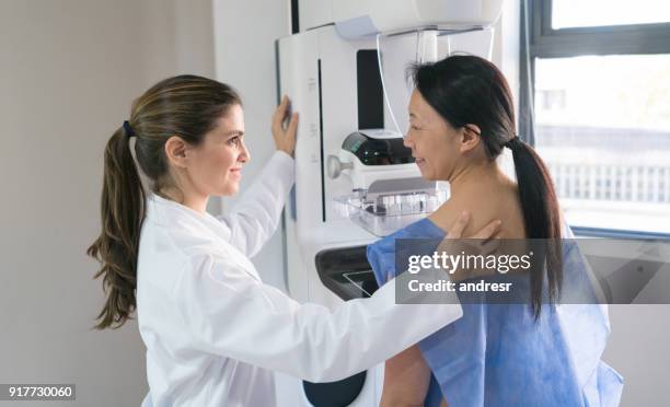 feminina ginecologista ajudando um patinet entrar posicion para uma mamografia - tetas - fotografias e filmes do acervo
