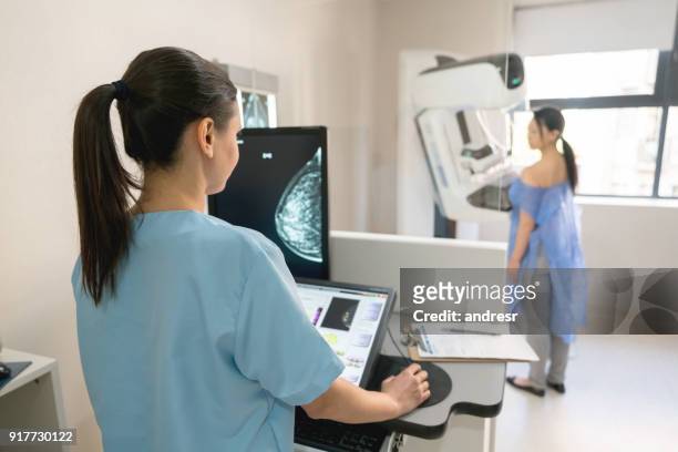 infermiera irriconoscibile che prende un esame di mammografia a un paziente adulto - seno foto e immagini stock