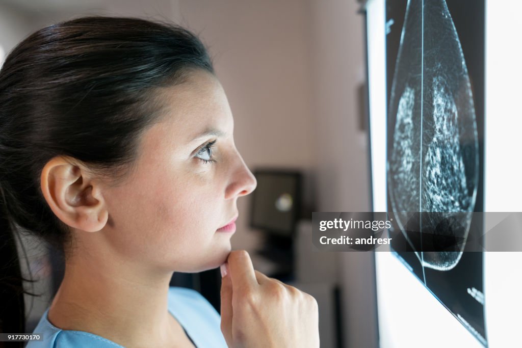 Ginecologista feminina olhando uma mamografia muito preocupada