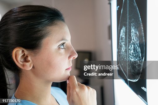 Ginecologista feminina olhando uma mamografia muito preocupada Ginecologista feminina olhando uma mamografia muito preocupada