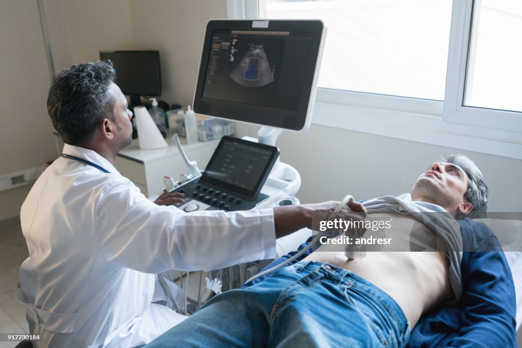 Middle eastern doctor doing an ultrasound scan to a middle aged man