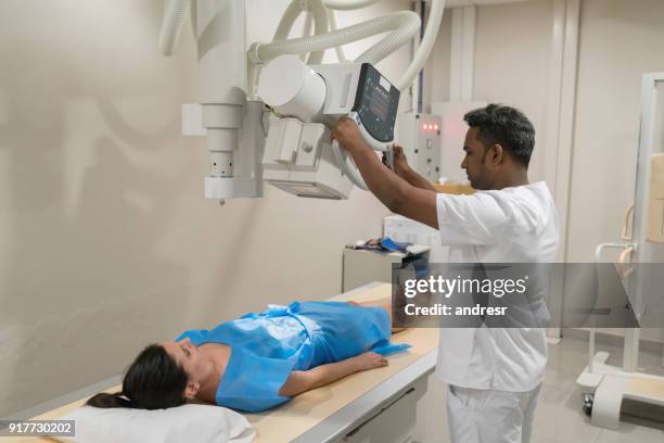 patiente couchée prêt pour une radiographie et le radiologue prêt la machine - équipement de radiologie photos et images de collection