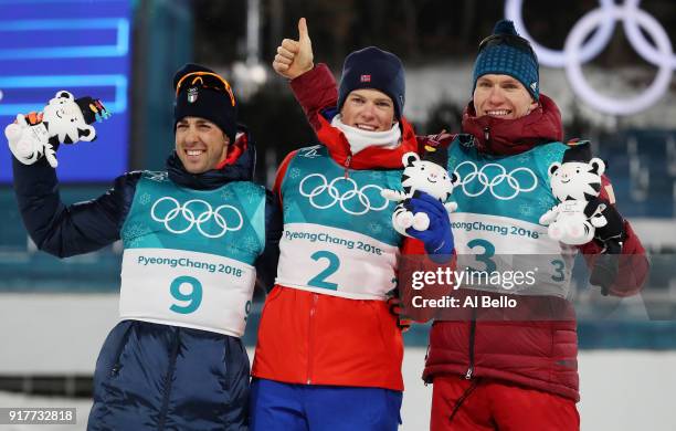 Silver medalist Federico Pellegrino, gold medalist Johannes Hoesflot Klaebo of Norway and Alexander Bolshunov of Olympic Athlete from Russia pose...