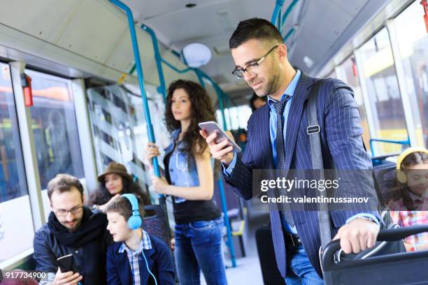 joven empresario viajando al trabajo y el uso de teléfonos inteligentes - melbourne australia fotografías e imágenes de stock