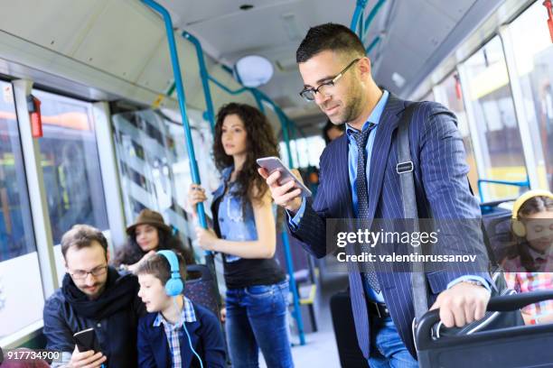 young businessman traveling to work and using smart phone - melbourne train stock pictures, royalty-free photos & images