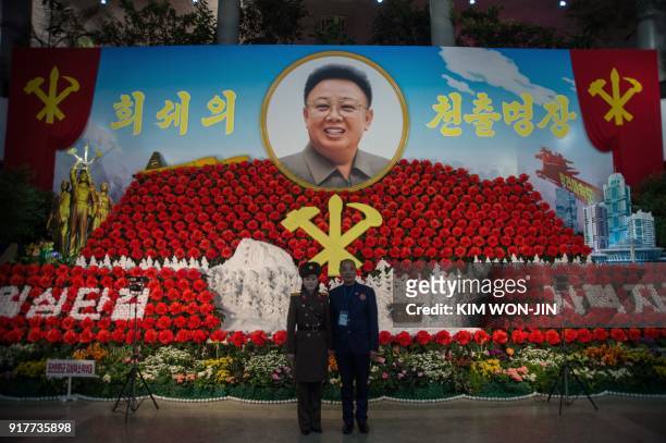 Foreign visitor stands for a photo with a Korean People's Army soldier in front of a portrait of late North Korean leader Kim Jong IL, at the 22nd...