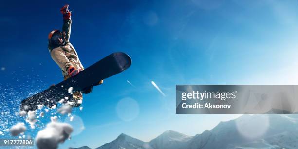 männliche extreme freestyle-snowboarder springen - big air stock-fotos und bilder