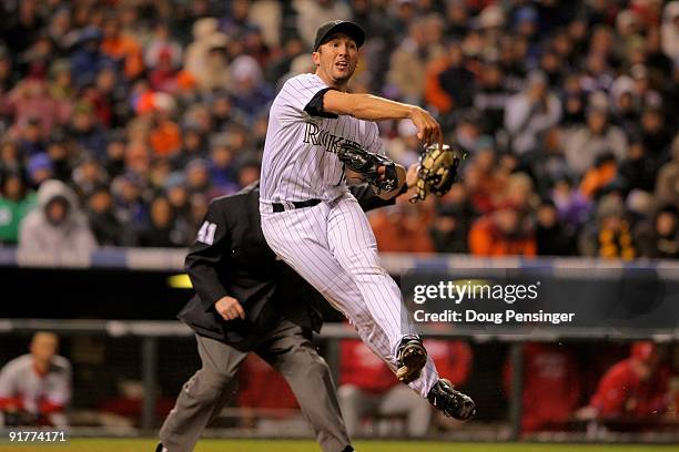 Pitcher Huston Street of the Colorado Rockies attempts to throw out Chase Utley of the Philadelphia Phillies at first base as Utley was called safe...