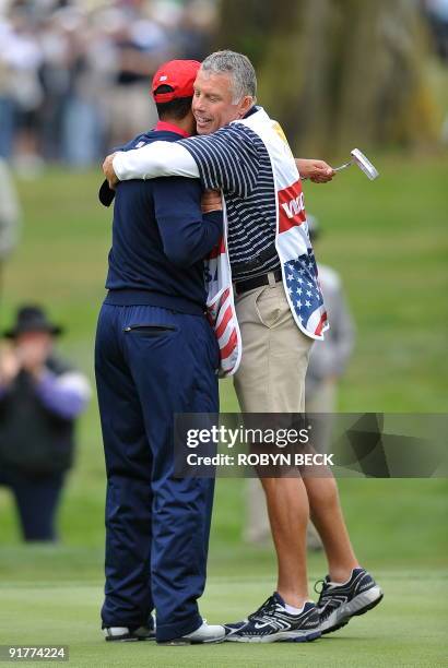 Team member Tiger Woods hugs his caddie Steve Williams after the US Team won the Presidents Cup golf competition after the American's won the...