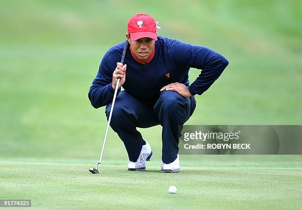 Team member Tiger Woods lines up his shot on the first green, during the final round -singles matches at the Presidents Cup golf competition on...