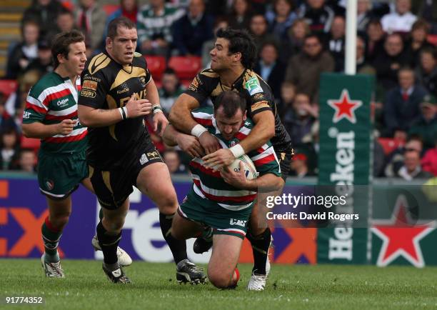 George Chuter of Leicester is tackled by Mike Phillips during the Heineken Cup match between Leicester Tigers and Ospreys at Welford Road on October...