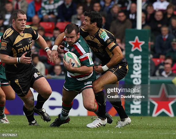 George Chuter of Leicester is tackled by Mike Phillips during the Heineken Cup match between Leicester Tigers and Ospreys at Welford Road on October...