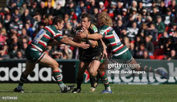 Tommy Bowe of the Ospreys is tackled by Craig Newby and Billy Twelvetrees during the Heineken Cup match between Leicester Tigers and Ospreys at...