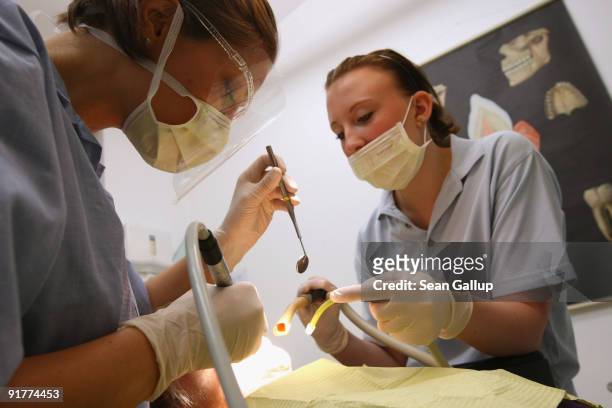 Dentist and her assistant prepare to clean a patient's teeth in this photo illustration at a dentist's office on October 12, 2009 in Berlin, Germany....
