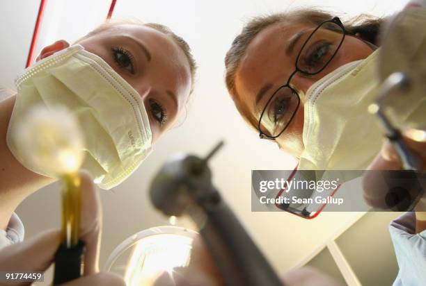 Dentist and her assistant prepare to clean a patient's teeth in this photo illustration at a dentist's office on October 12, 2009 in Berlin, Germany....