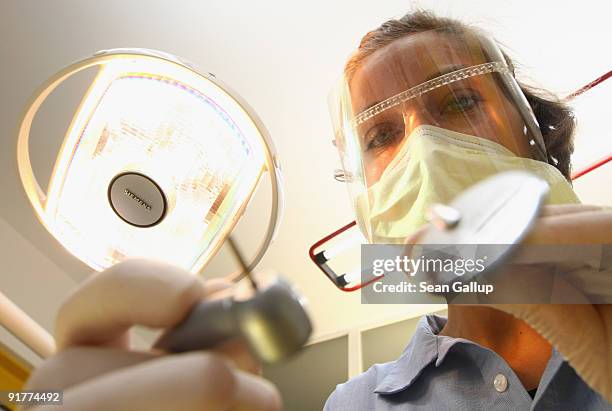 Dentist prepares to clean a patient's teeth in this photo illustration at a dentist's office on October 12, 2009 in Berlin, Germany. German political...