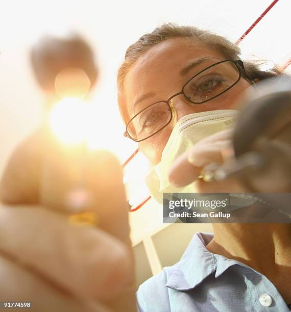 Dentist prepares to clean a patient's teeth in this photo illustration at a dentist's office on October 12, 2009 in Berlin, Germany. German political...