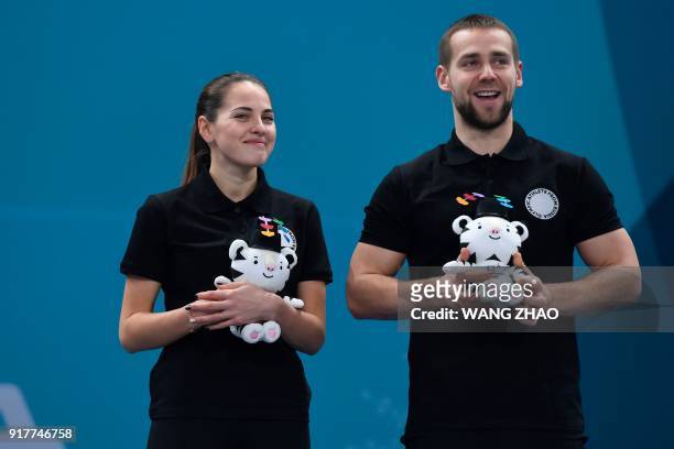 Russia's bronze medallist Anastasia Bryzgalova and Aleksandr Krushelnitckii celebrate on the podium during the curling mixed doubles venue ceremony...