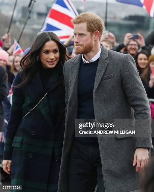 Britain's Prince Harry and his fiancée US actress Meghan Markle meet members of the public during a walkabout on the Esplanade at Edinburgh Castle,...