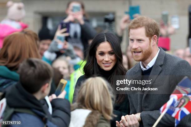 Prince Harry and Meghan Markle salute the crowd as they arrive to Edinburgh Castle on February 13, 2018 in Edinburgh, Scotland.