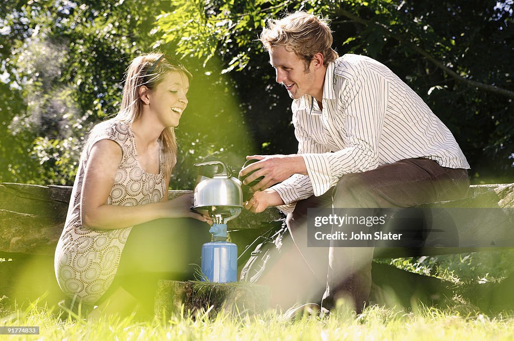 Couple making hot drinks outside