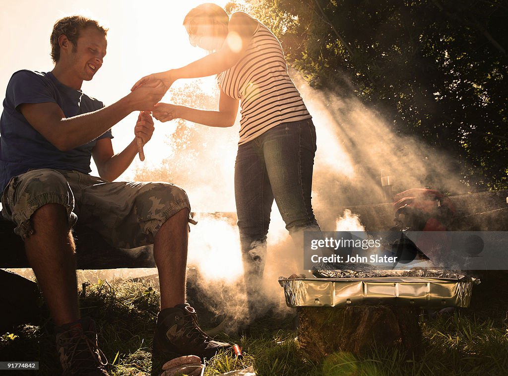 Couple sorting food out next to BBQ