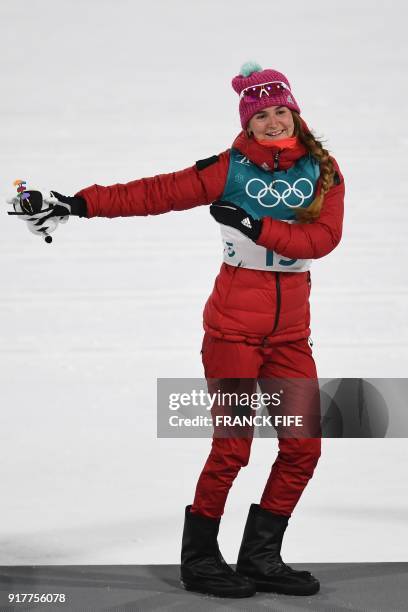 Bronze medallist Russia's Yulia Belorukova dances on the podium during the victory ceremony in the women's cross-country individual sprint classic...