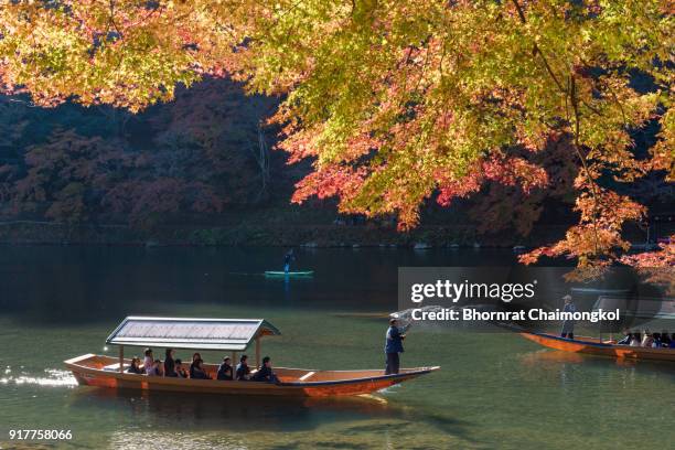 boatman punting the boat for tourists to enjoy the beautiful autumn view along the hozu river in arashiyama at kyoto - 渡月橋 ストックフォトと画像