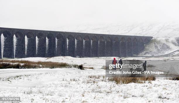 Walkers pass Ribblehead Viaduct in Yorkshire surrounded by heavy snow, as forecasters have issued a series of yellow weather warnings which affect...