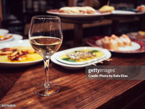 glass of white wine and some spanish tapas - san sebastian spain stock pictures, royalty-free photos & images