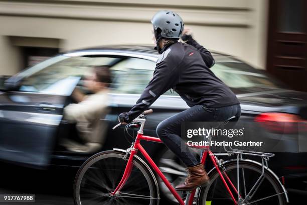 Posed scene of a driver who suddenly opens the door of the car during a cyclist passes the car on February 13, 2018 in Berlin, Germany.