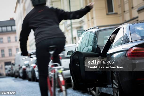 Posed scene of a driver who suddenly opens the door of the car during a cyclist passes the car on February 13, 2018 in Berlin, Germany.