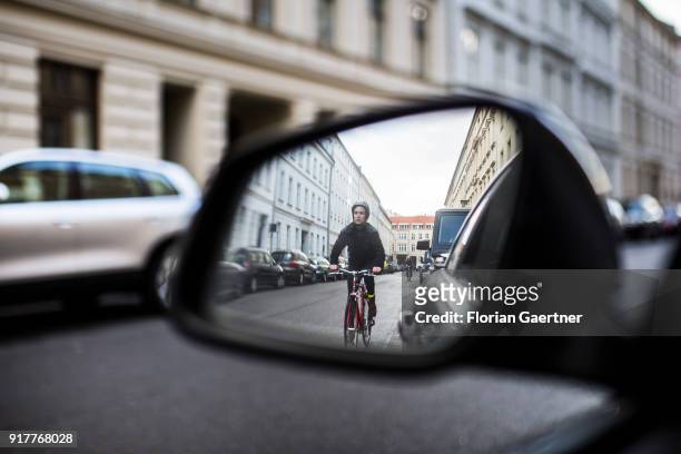 Posed scene of a cyclist seen through the side mirror of a car on February 13, 2018 in Berlin, Germany.