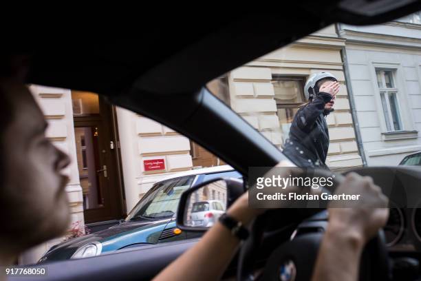 Posed scene of a cyclist gets excited about a car driver on February 13, 2018 in Berlin, Germany.