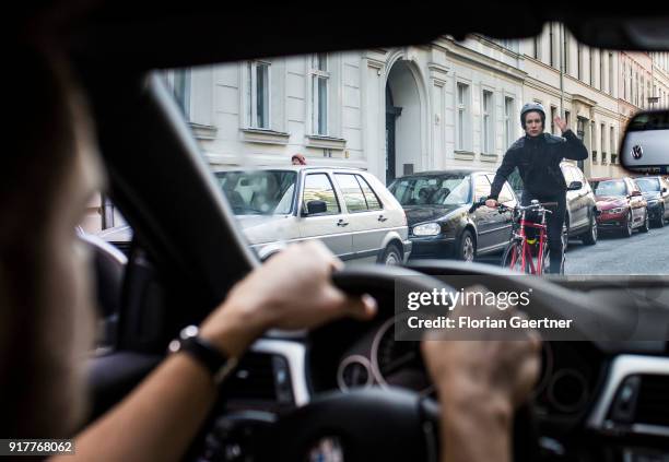 Posed scene of a cyclist gets excited about a car driver on February 13, 2018 in Berlin, Germany.