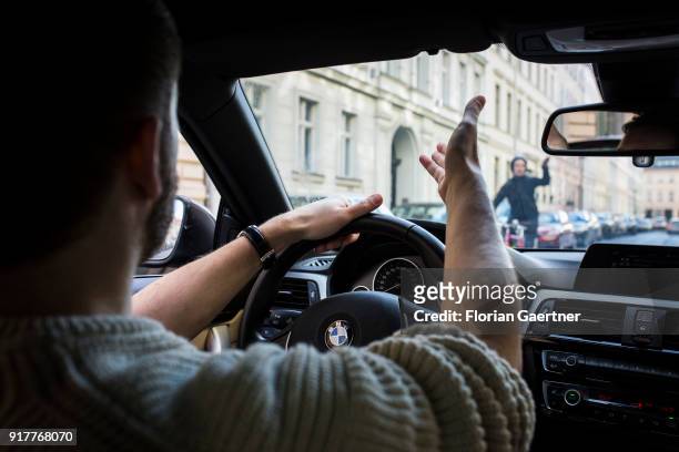 Posed scene of a cyclist and a car driver get excited about each other on February 13, 2018 in Berlin, Germany.
