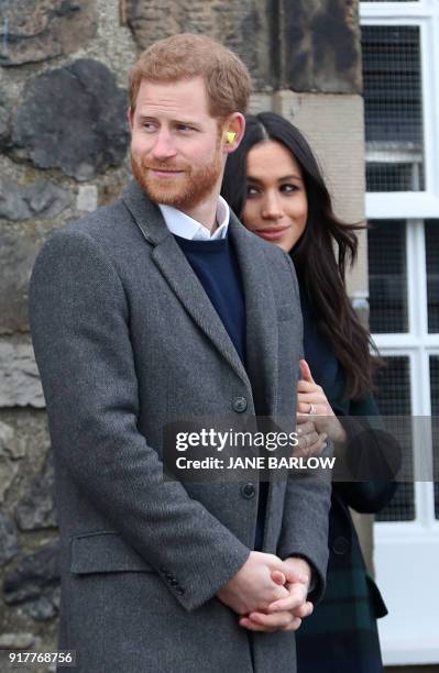 Britain's Prince Harry and his fiancée, US actress Meghan Markle look on after watching the firing of the One o'clock gun at Edinburgh Castle during...