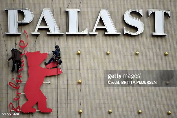Industrial climbers fix a Berlinale Bear at the Zoo Palast cinema in Berlin, on February 13 two days ahead of the opening of the festival. The 2018...
