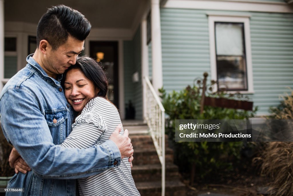 Portrait of young couple in front of home