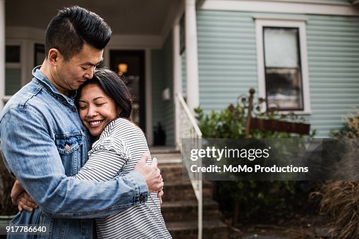 Portrait of young couple in front of home Portrait of young couple in front of home