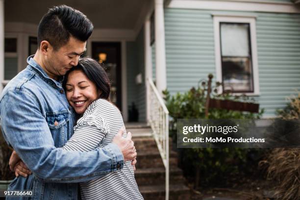 Portrait of young couple in front of home