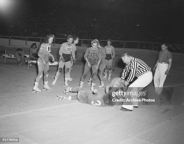 The referee intervenes in an incident during an international roller derby at Harringay Arena, London, 1953.