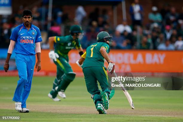 India bowler Jasprit Bumrah walks by South African batsmen Aiden Markram and Hashim Amla making their grounds during the fifth One Day International...