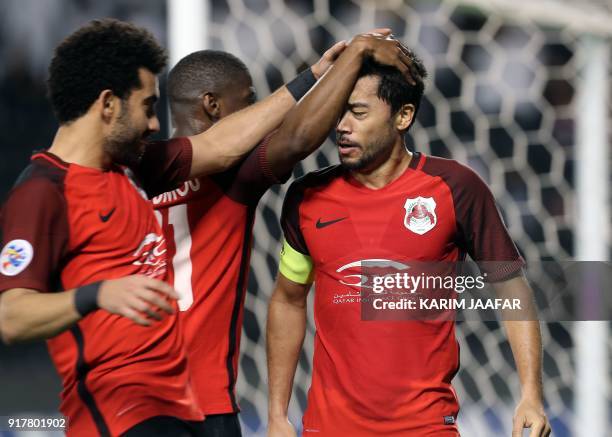 Players of Qatar's Qatar's Al-Rayyan SC congratulate their Qatari-Brazilian midfielder and captain Rodrigo Tabata after he scored a goal against...